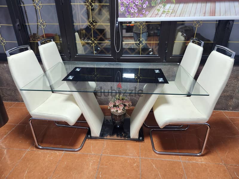 Glass dinning table with 4 chairs for sale in white colour 1